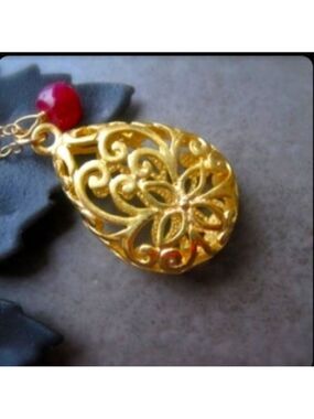 Filigree gold pendant with ruby